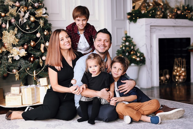 Beautiful big family spend time at home near the Christmas tree