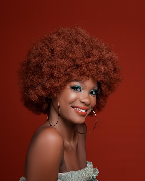 Photo a beautiful black african model having gorgeous smile in a studio on a red background