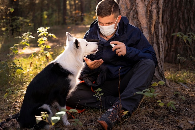 Beautiful black and white dog and man wearing mask