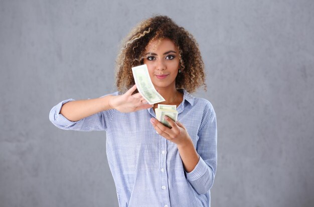 Beautiful black woman portrait scattering money notes