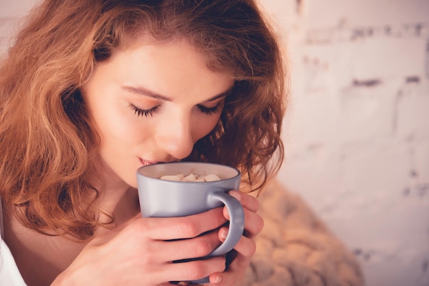 Beautiful blond woman drinking a coffee in her bed Lifestyle concept