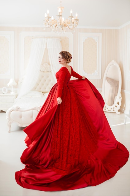 Beautiful blond woman in red posing in vintage interior