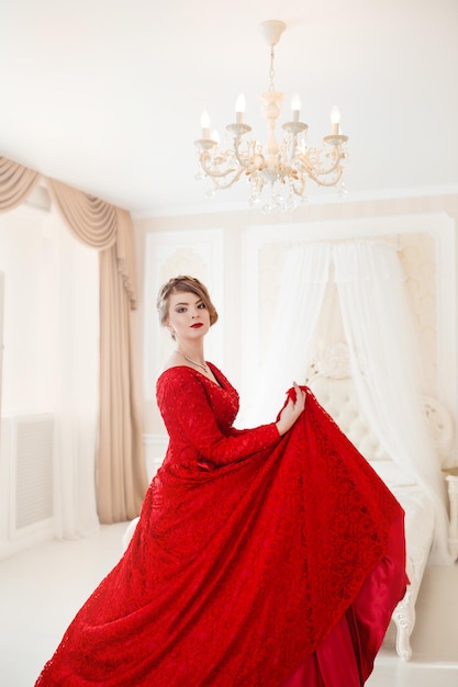 Beautiful blond woman in red posing in vintage interior