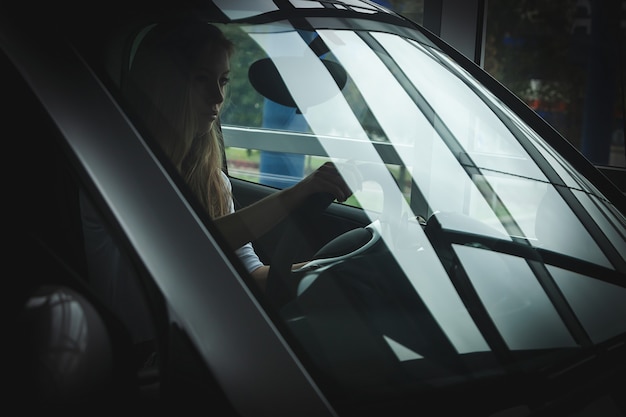 Beautiful blonde driving a car, learning to drive a car for girls, driving school.