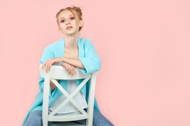 Photo beautiful blonde female looks aside with bewilderment poses against pink background body language and face expression image