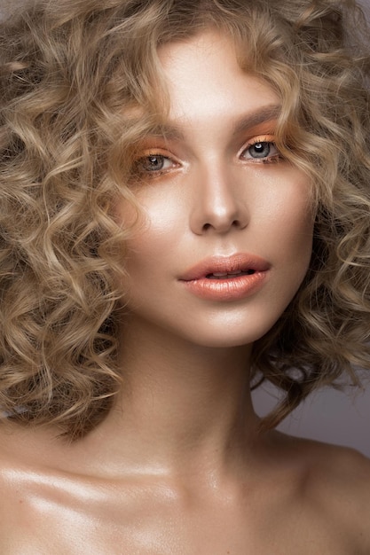 Beautiful blonde girl with curls and gentle makeup Beauty face