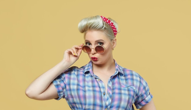 Beautiful blonde posing on a yellow background