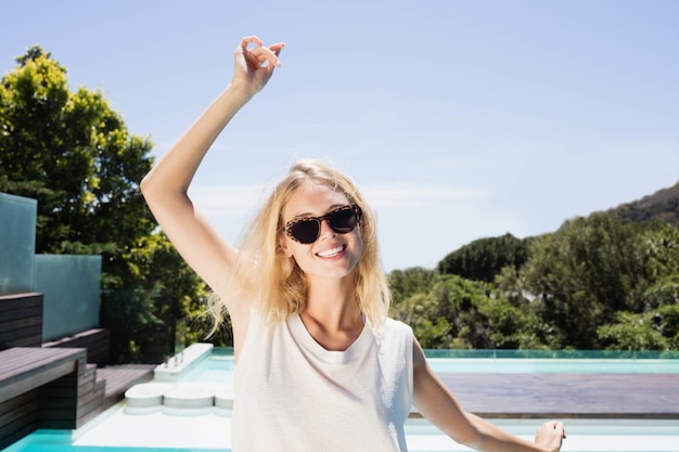 Beautiful blonde smiling at the camera by the pool