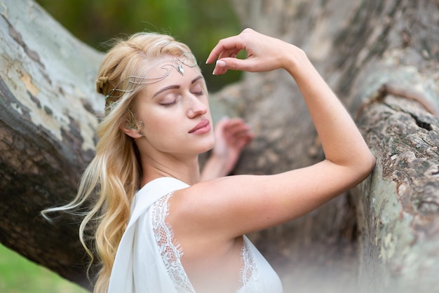 Beautiful blonde in a white dress with a chic hairstyle closeup