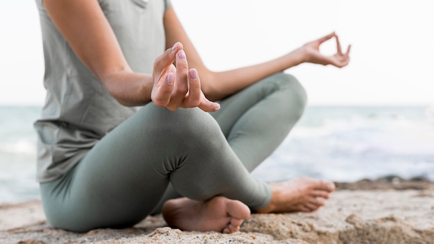 Beautiful blonde woman doing yoga at the beach