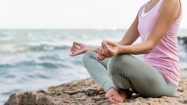 Beautiful blonde woman doing yoga at the beach