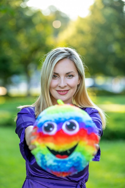 Beautiful Blonde Woman is Playing with Colorful Ball in Park