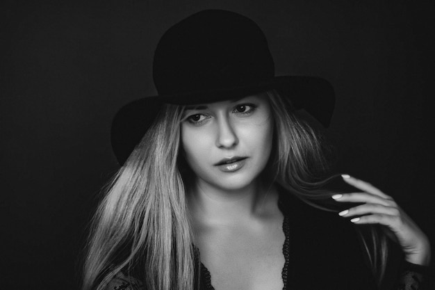 Beautiful blonde woman wearing a hat artistic film portrait in black and white for fashion campaign and beauty brand