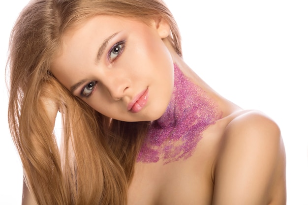 Beautiful blonde woman with bright makeup and glitter on her neck on white background