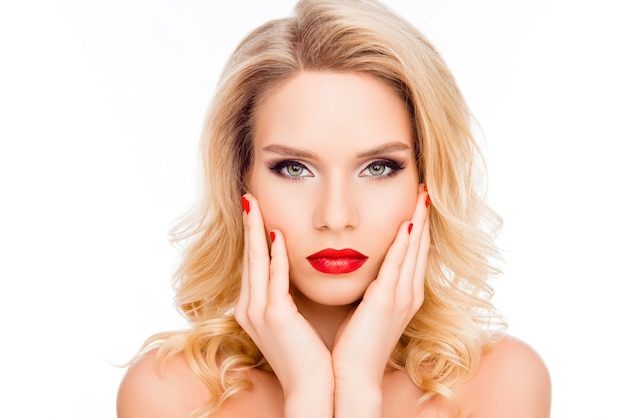 Beautiful blonde woman  with red lips and manicure touching her face