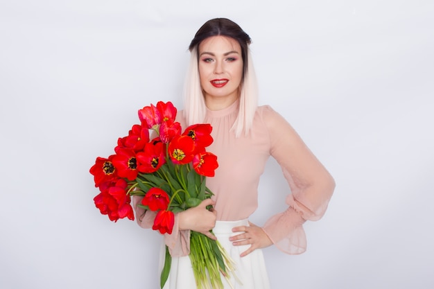 Beautiful blonde woman with red tulips