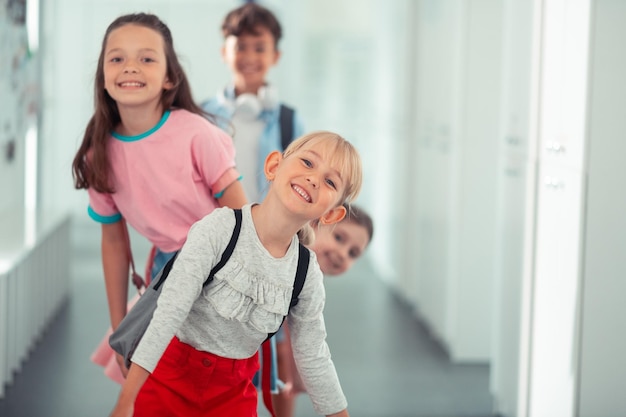 Beautiful blondehaired girl spending time with friends at school