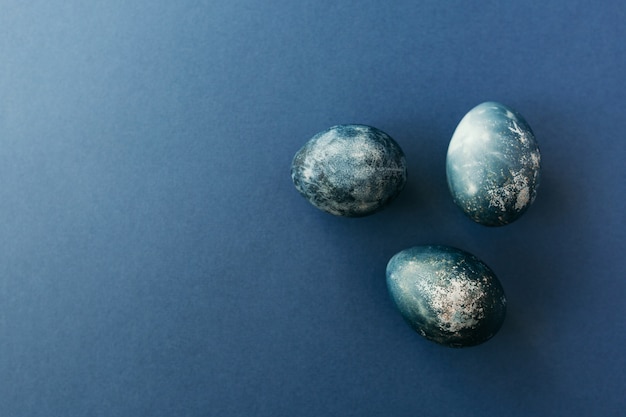 Beautiful blue Easter eggs with quail eggs and feathers. Easter concept. Border eggs. Copy space for text.