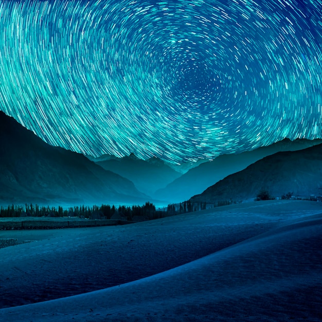 Beautiful blue night desert and dune on star trail background