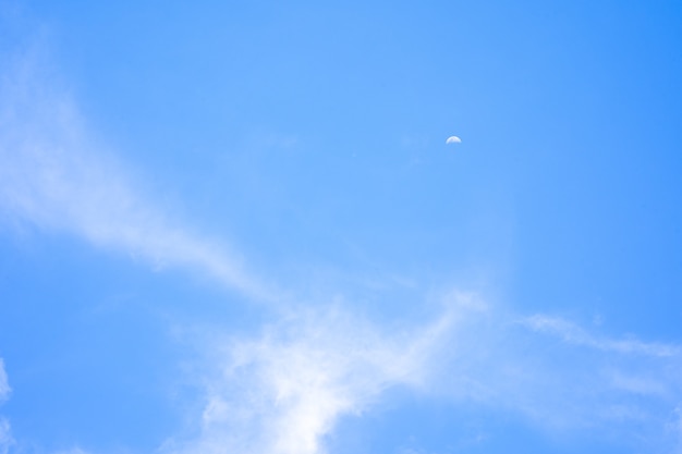 Beautiful blue sky with tiny white cloud and crescent moon as background