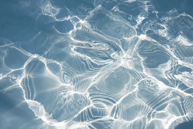 Beautiful blue water surface with bright sun light reflections. blue water in swimming pool background