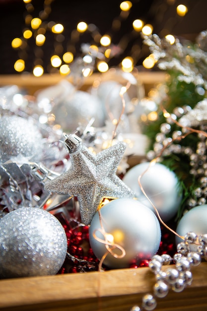 Beautiful bokeh. Christmas background. Fir branches, Christmas decor, cones, red and silver balls, red beads