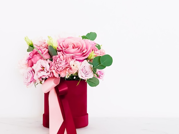 Beautiful bouquet of blooming flowers in red flower box on white background holiday gift luxury floral design