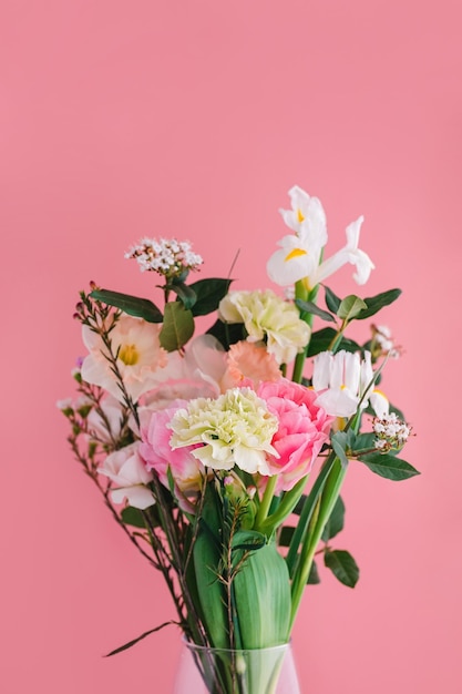 Beautiful bouquet of carnations daffodils spray roses Chamelacium hookata and white irises on pink