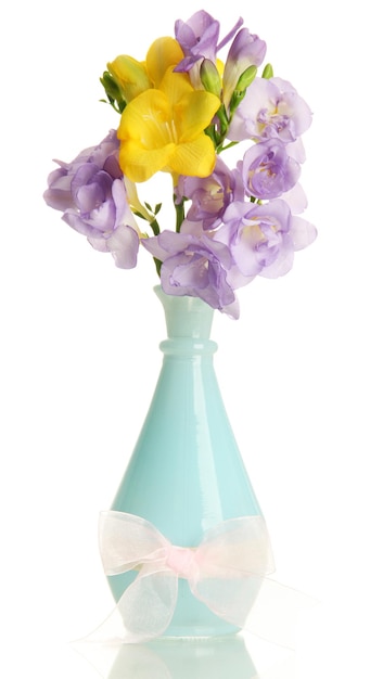 Beautiful bouquet of freesias in vase isolated on white