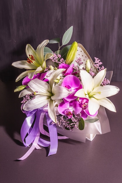 A beautiful bouquet of fresh flowers on a black wooden background