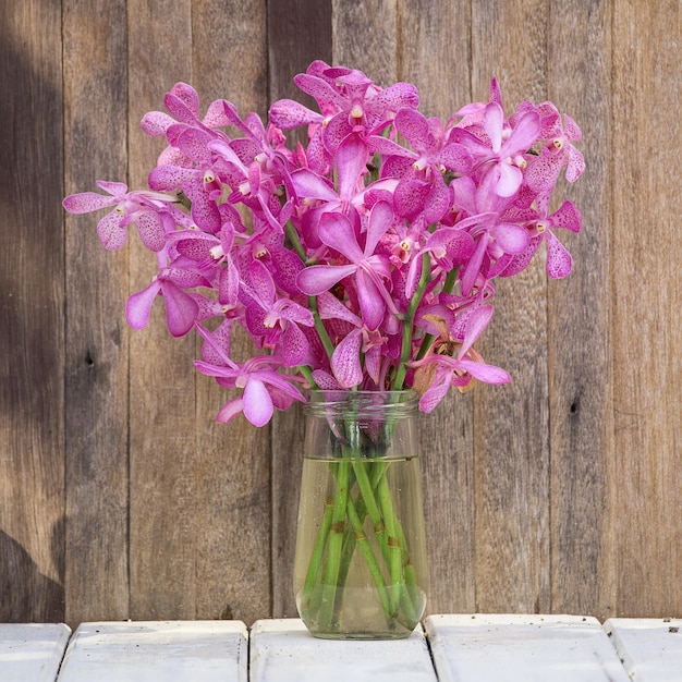 Beautiful bouquet of orchids flower on a wooden background