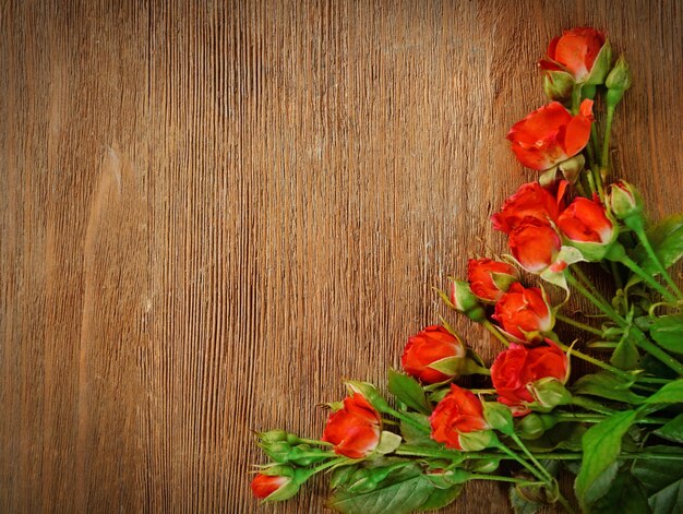 Beautiful bouquet of pink little roses on wooden background copy space