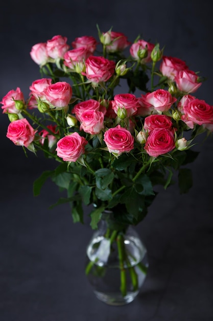 Beautiful bouquet of pink red roses bushes on a black background Selective focus closeup