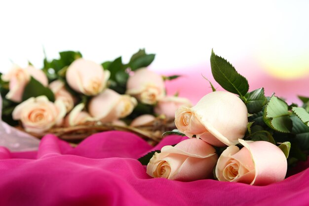 Beautiful bouquet of roses, on fabric, on light background