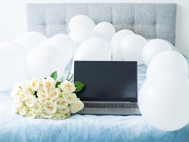 Beautiful bouquet of white blooming roses on the bed