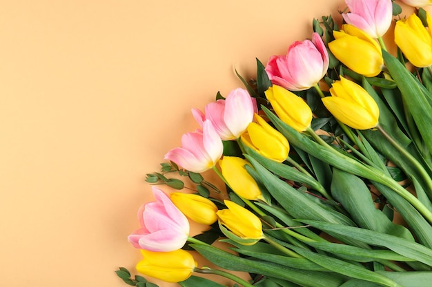 Beautiful bouquet of yellow and pink tulips on beige background