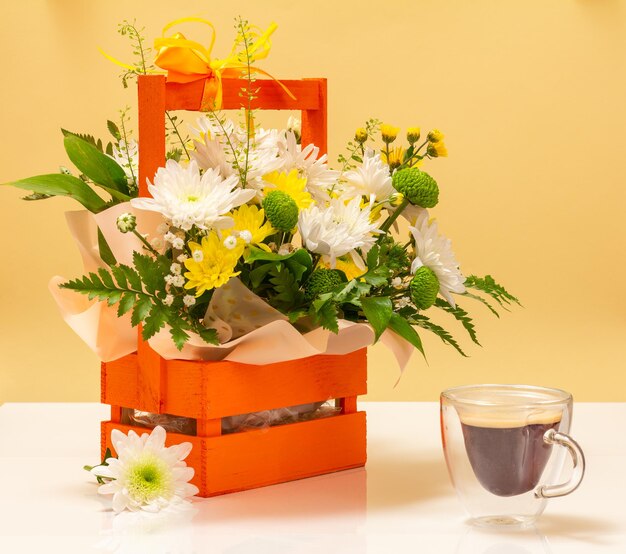 Beautiful bouquet of yellow and white flowers with wooden basket