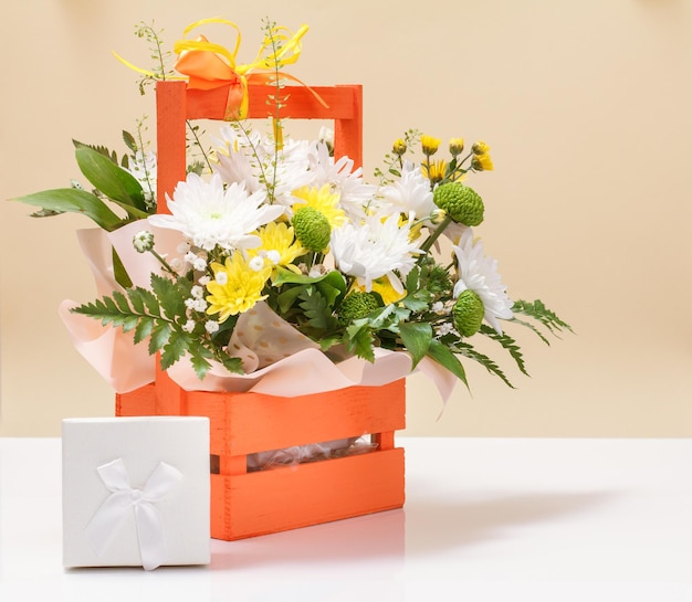 Beautiful bouquet of yellow and white flowers with wooden basket