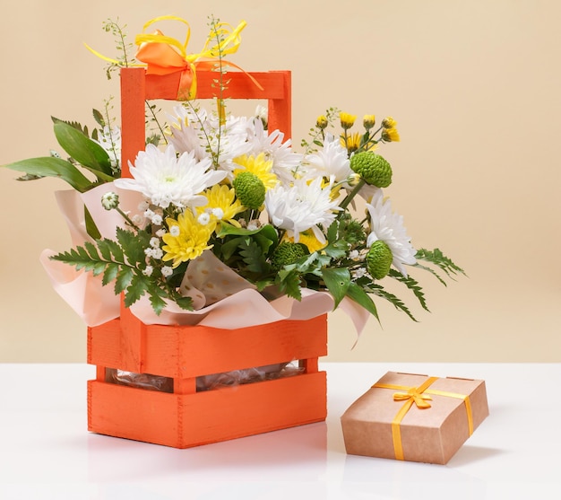 Beautiful bouquet of yellow and white flowers with wooden basket