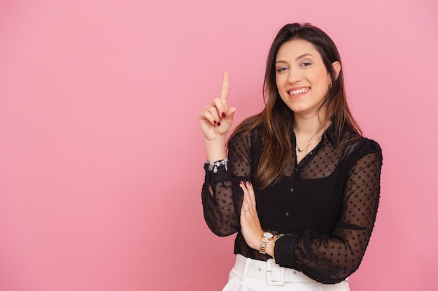 Beautiful Brazilian Caucasian Woman Pink Background with Raised Finger Suggesting Idea Question and Suggestion Entrepreneur