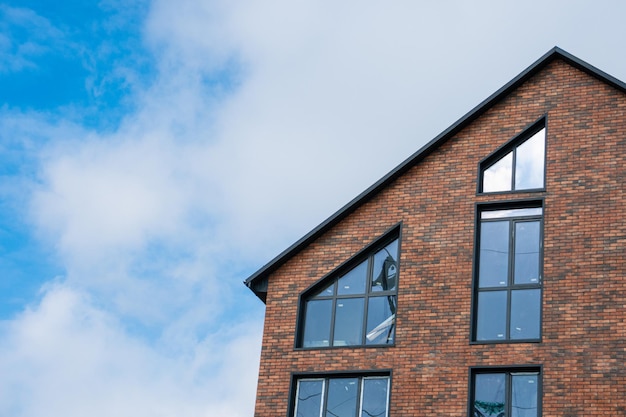 A beautiful brick building with large windows on the background of the blue sky