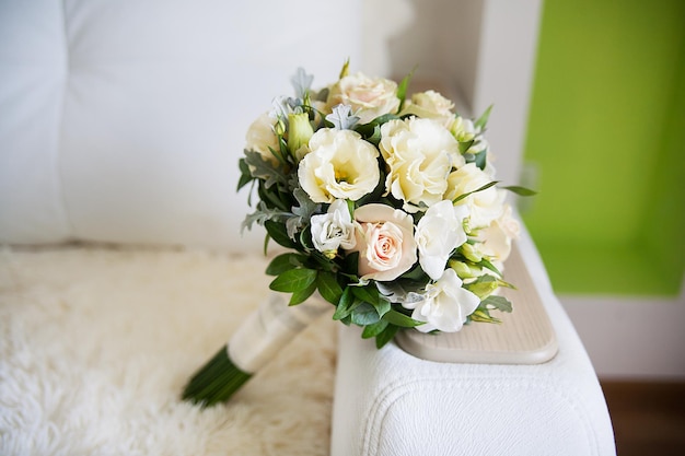 Beautiful bridal bouquet lying on sofa