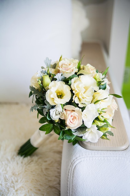 Beautiful bridal bouquet lying on sofa