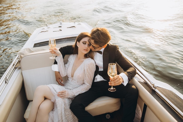 Beautiful bride and groom ride a yacht drink wine and enjoy the moment Wedding day