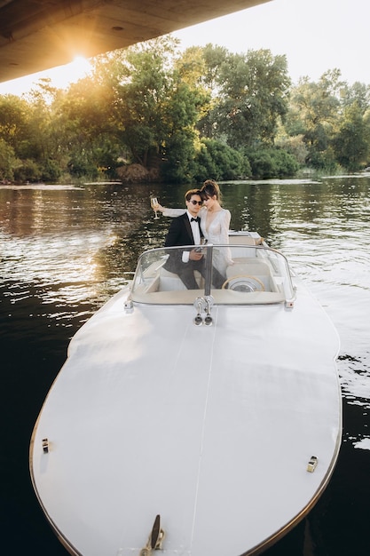 Beautiful bride and groom ride a yacht drink wine and enjoy the moment Wedding day