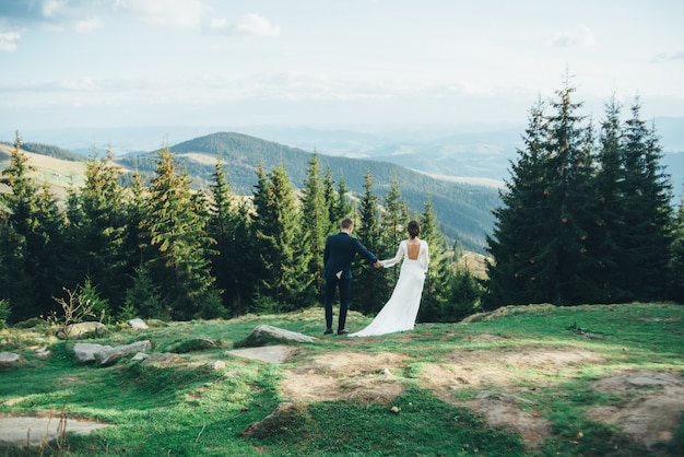 Beautiful bride and groom staying in the mountains