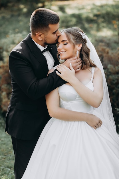 Beautiful bride and groom at sunset in green nature.