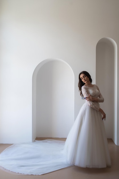 Beautiful bride in a magnificent white wedding dress of tulle with corset lacing and long beauty hai