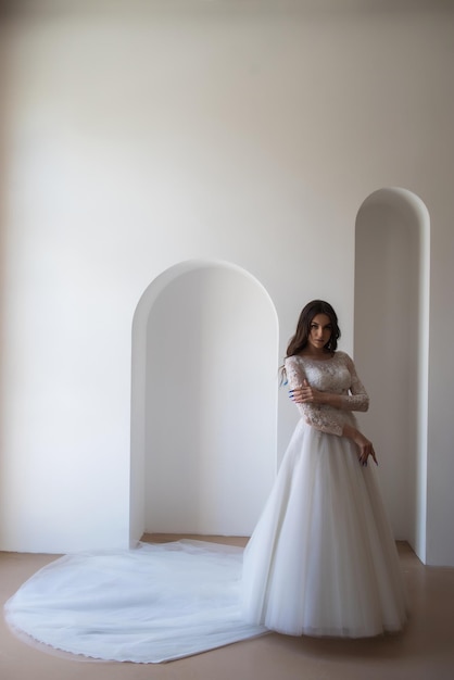 Beautiful bride in a magnificent white wedding dress of tulle with corset lacing and long beauty hai