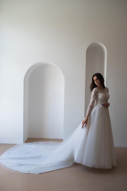 Beautiful bride in a magnificent white wedding dress of tulle with corset lacing and long beauty hai